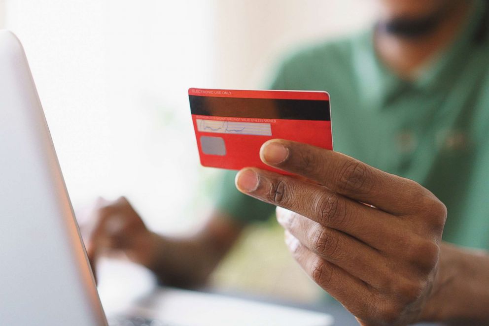 PHOTO: A man uses a credit card while shopping online.