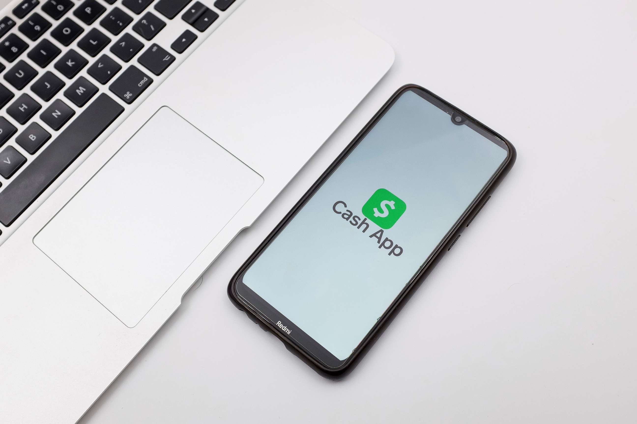 PHOTO: In this photo illustration a Cash App logo seen displayed on a smartphone screen on a desk next to a Macbook in Athens, Greece, Oct. 4, 2022.
