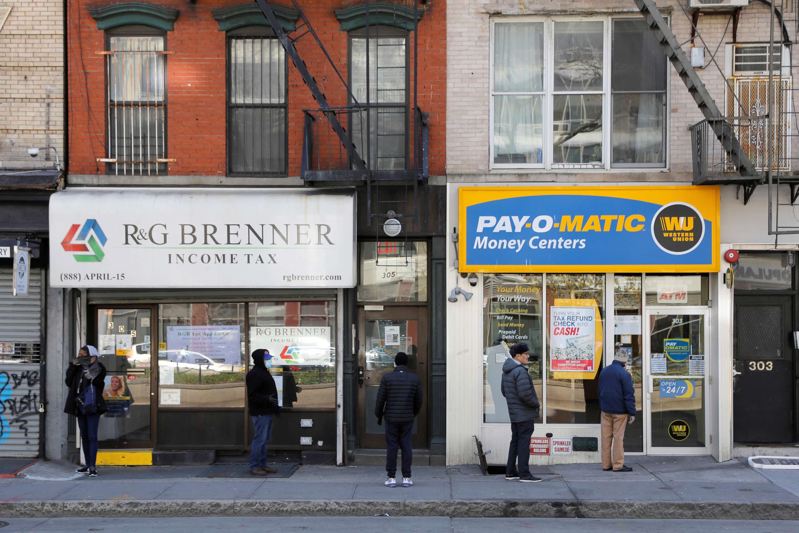 PHOTO:People queue to enter Payomatic, a business that offers check cashing, as unemployment claim figures were released, during the coronavirus disease (COVID-19) outbreak in Manhattan, New York City, April 2, 2020.
