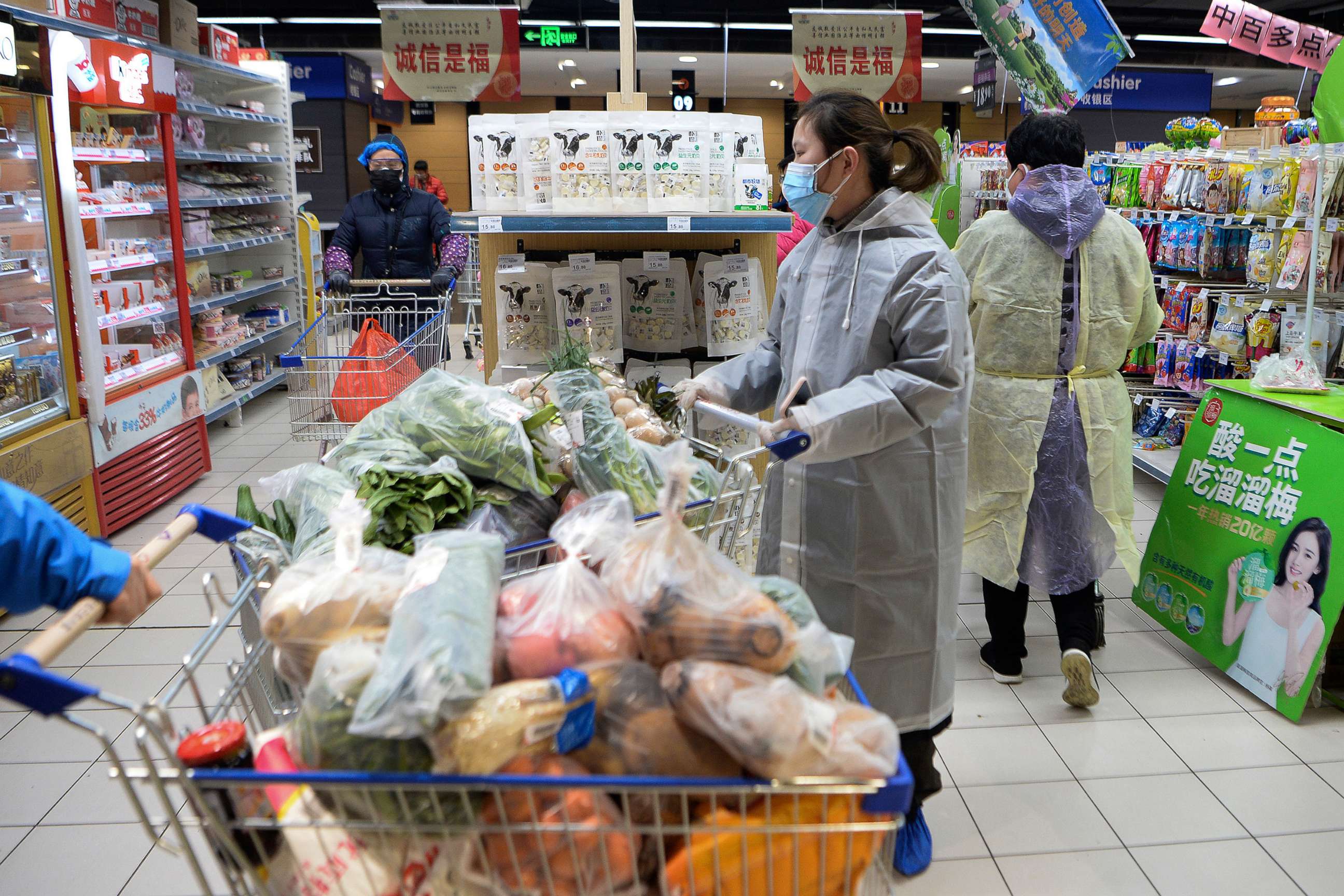 PHOTO: Women wearing protective face masks and raincoats buy foods at a supermarket in Wuhan in central China's Hubei province, Feb. 10, 2020.