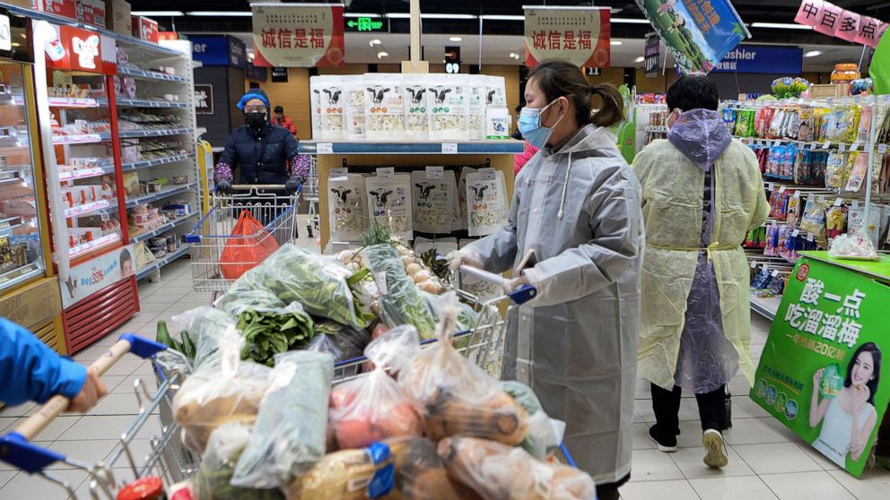 PHOTO: Women wearing protective face masks and raincoats buy foods at a supermarket in Wuhan in central China's Hubei province, Feb. 10, 2020.