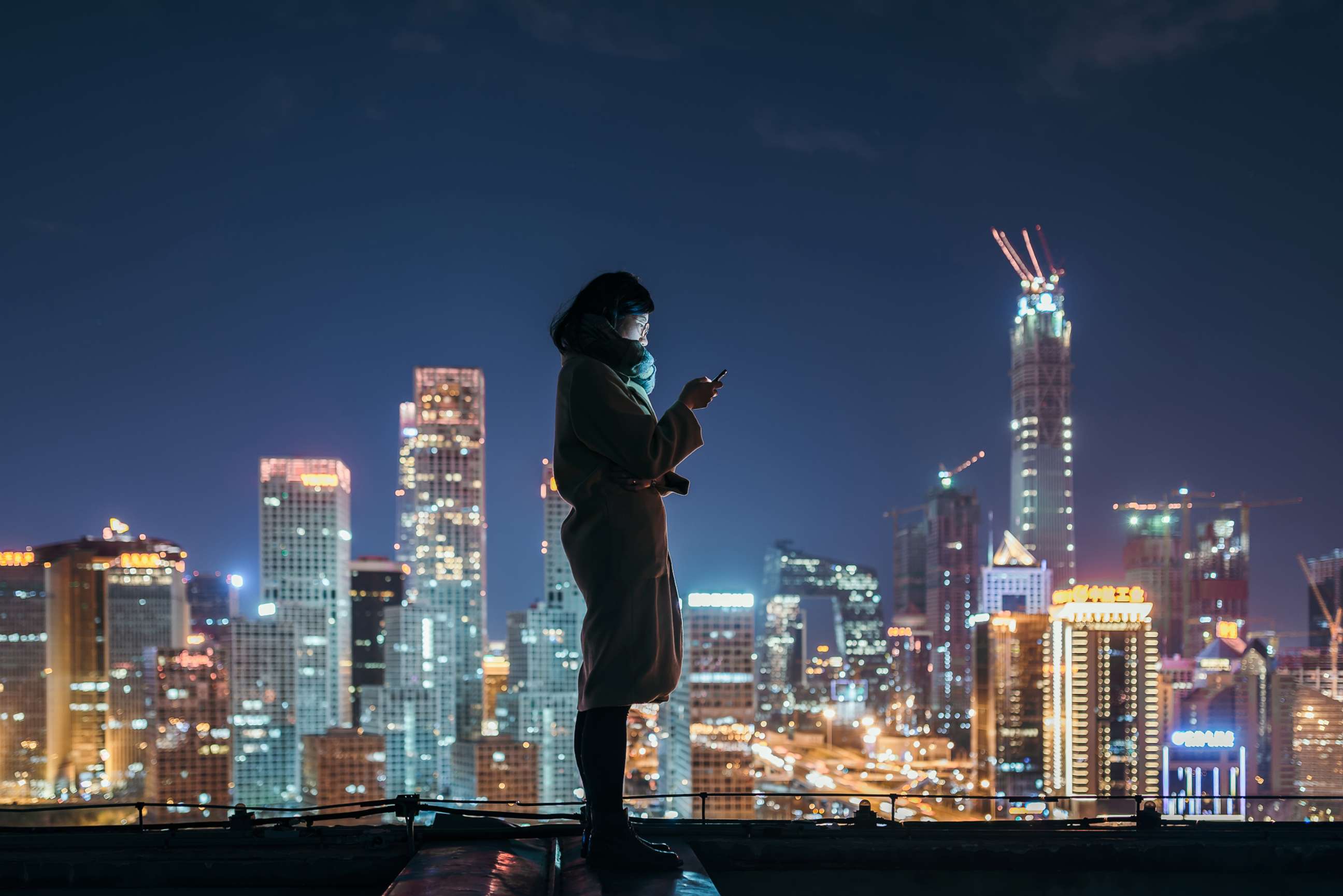 PHOTO:A woman looks at her phone in Beijing. 