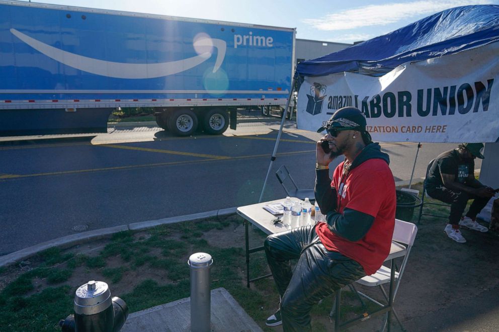 PHOTO: Chris Smalls, president of the Amazon Labor Union, talks on his phone while an Amazon truck passes by in the Staten Island borough of New York, Oct. 21, 2021.
