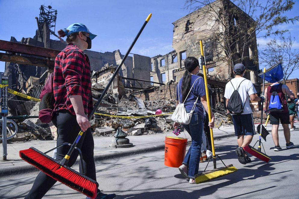 PHOTO: People gather for a community-wide grassroots cleanup, May 31, 2020, in Minneapolis, to secure buildings and clean up debris from protests sparked by the death of George Floyd.
