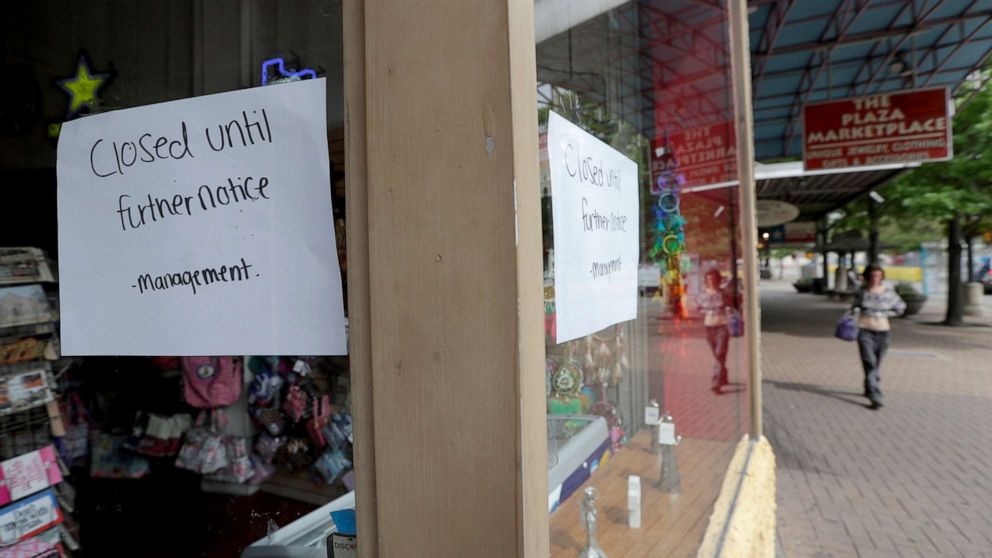 PHOTO: A pedestrian passes a business which has closed temporarily in San Antonio, Texas, March 24, 2020.