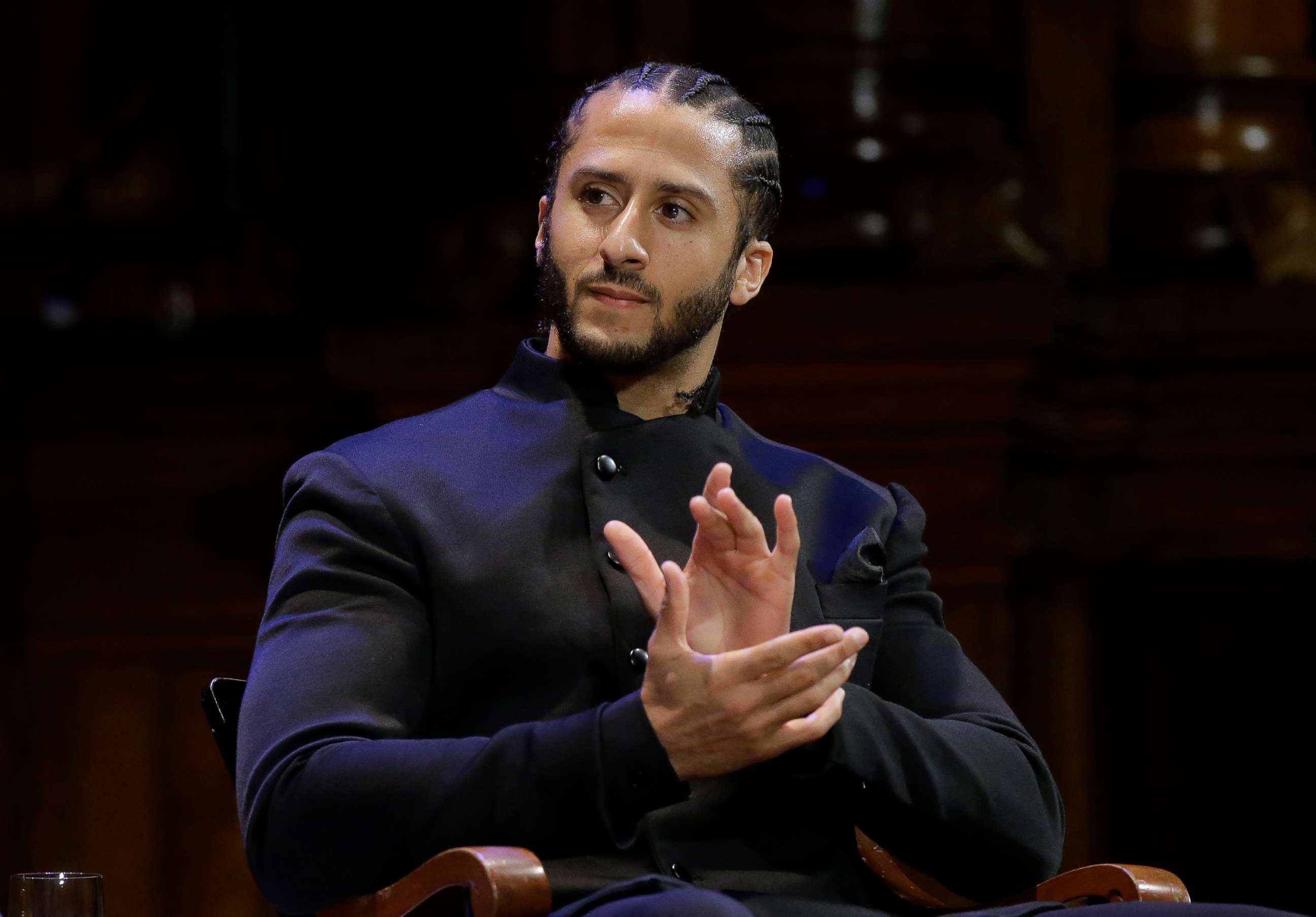 PHOTO: Former NFL football quarterback Colin Kaepernick applauds while seated on stage during W.E.B. Du Bois Medal ceremonies, Oct. 11, 2018, at Harvard University, in Cambridge, Mass.