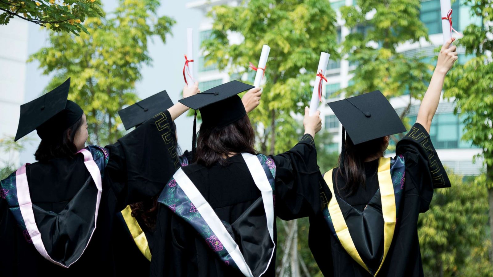 PHOTO: A rear view of female graduates wearing graduation caps and gowns at campus is captured in this undated stock photo.