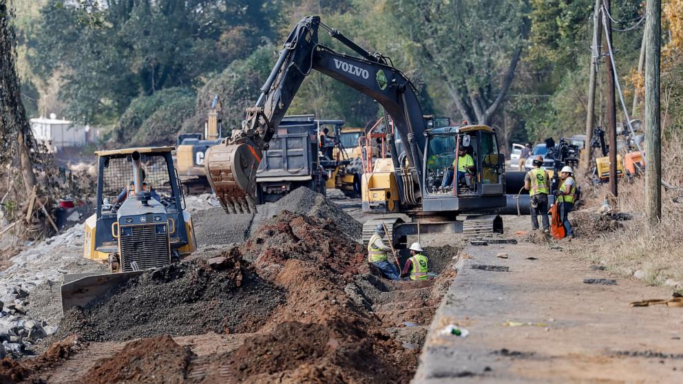 PHOTO: Construction and utility crews work to restore a water main and destroyed road in the aftermath of catastrophic flooding caused by Tropical Storm Helene in Swannanoa, NC, Oct. 3, 2024. 