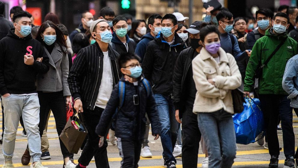 PHOTO: Pedestrians wearing face masks cross a road during a Lunar New Year of the Rat public holiday in Hong Kong on Jan. 27, 2020, as a preventative measure following a coronavirus outbreak which began in the Chinese city of Wuhan.
