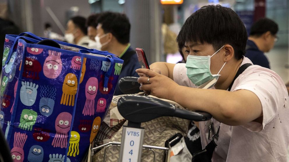 PHOTO: As Coronavirus spreads, a traveler wearing a mask checks his phone at Suvarnabhumi International airport in Bangkok, Thailand, Feb. 10, 2020.
