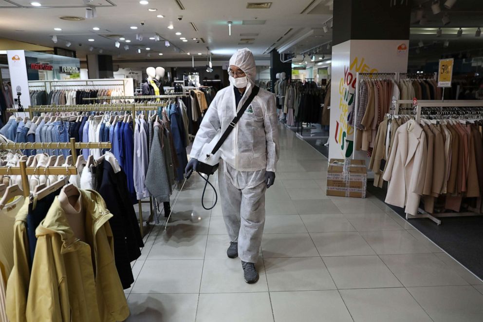 PHOTO: A disinfection professional, wearing protective gear, sprays antiseptic solution around a department store to guard against the coronavirus (COVID-19), March 2, 2020, in Seoul, South Korea.