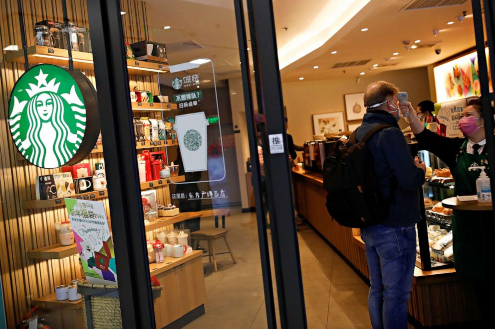 PHOTO: A worker uses a thermometer to check the temperature of a customer as he enters a Beijing Starbucks as China copes with an outbreak of the new coronavirus, Jan. 30, 2020.