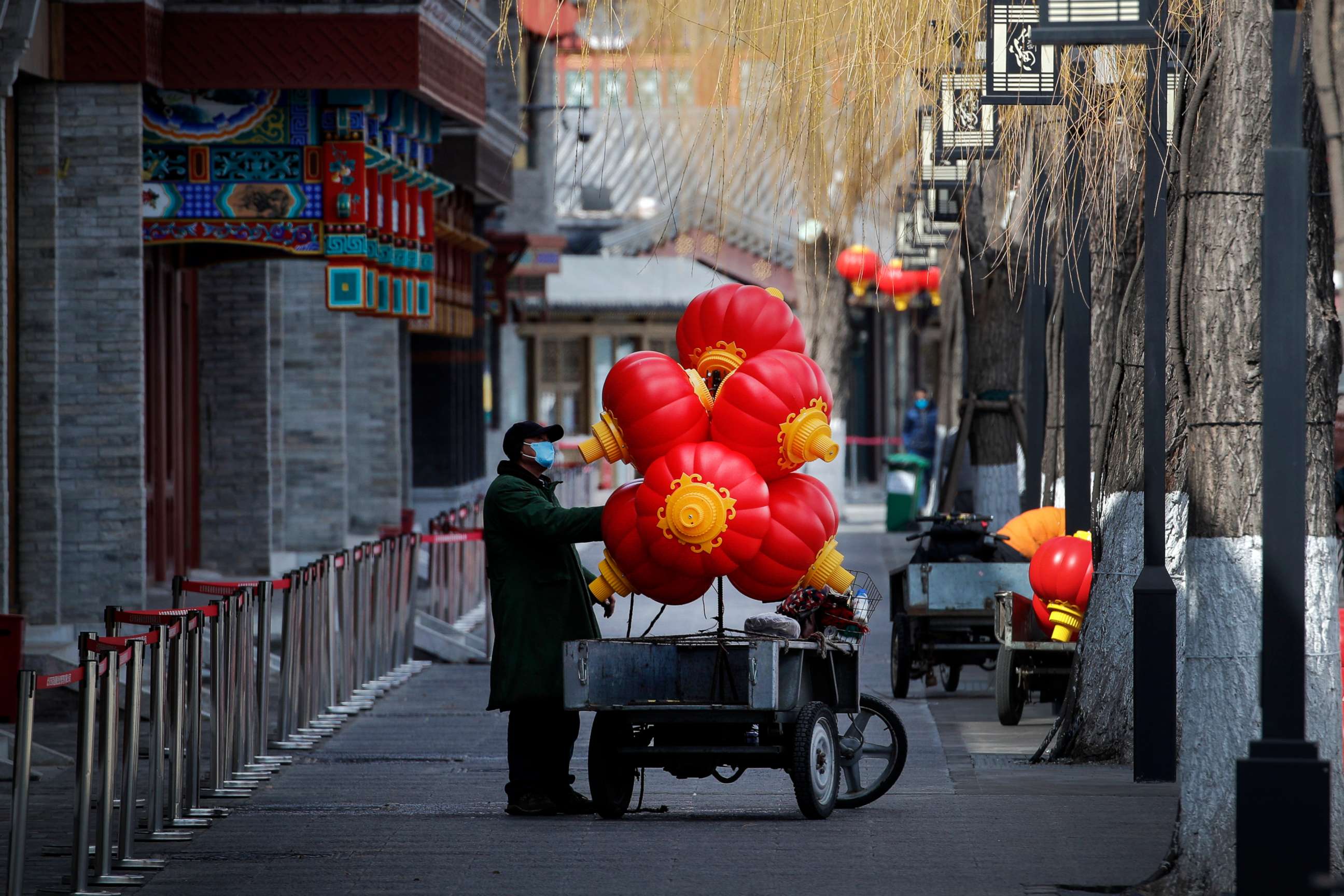 PHOTO: A worker wearing a protective face mask places lanterns on his cart near the closed restaurants along the Houhai Lake, a usually popular tourist spot before the coronavirus outbreak in Beijing, China, March 1, 2020.