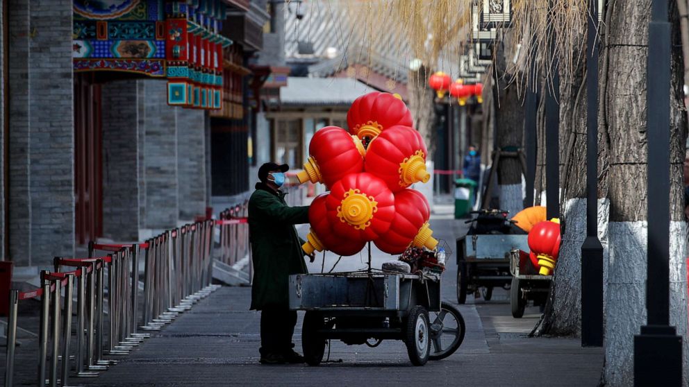 PHOTO: A worker wearing a protective face mask places lanterns on his cart near the closed restaurants along the Houhai Lake, a usually popular tourist spot before the coronavirus outbreak in Beijing, China, March 1, 2020.