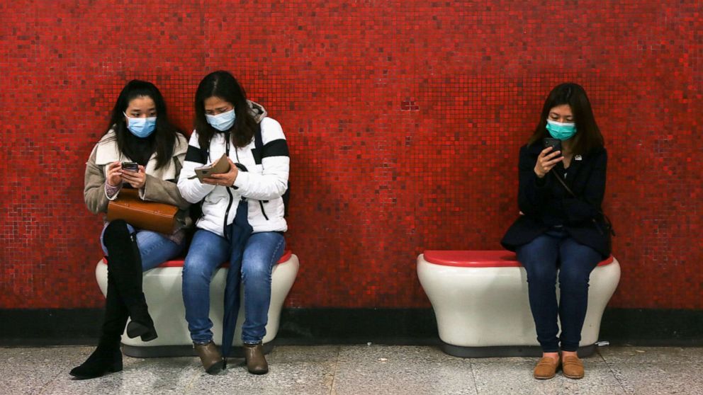 PHOTO: Passengers wearing face masks look at their mobile phones while waiting for the subway in Hong Kong, Jan. 26, 2020, during the Coronovirus outbreak.