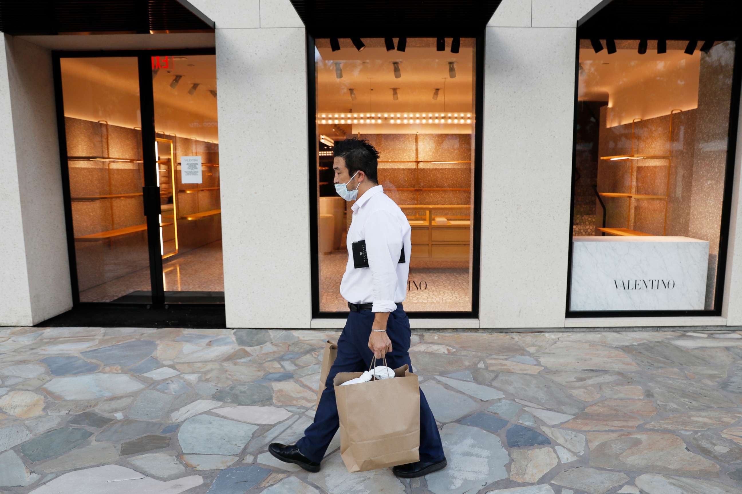 PHOTO: A man walks past an empty luxury shop in the tourist district of Waikiki as many businesses have temporarily closed across Hawaii due to the coronavirus disease, in Honolulu, April 28, 2020.