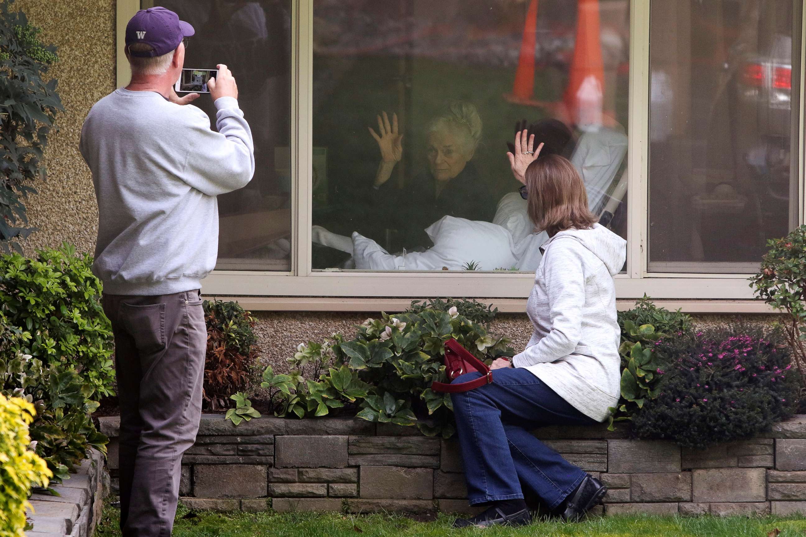 PHOTO: Lori Spencer and husband Michael Spencer visit outside the room of Lori's mom Judie Shape, 81, who Lori says has tested positive for coronavirus, at Life Care Center in Kirkland, Wash., March 11, 2020. 