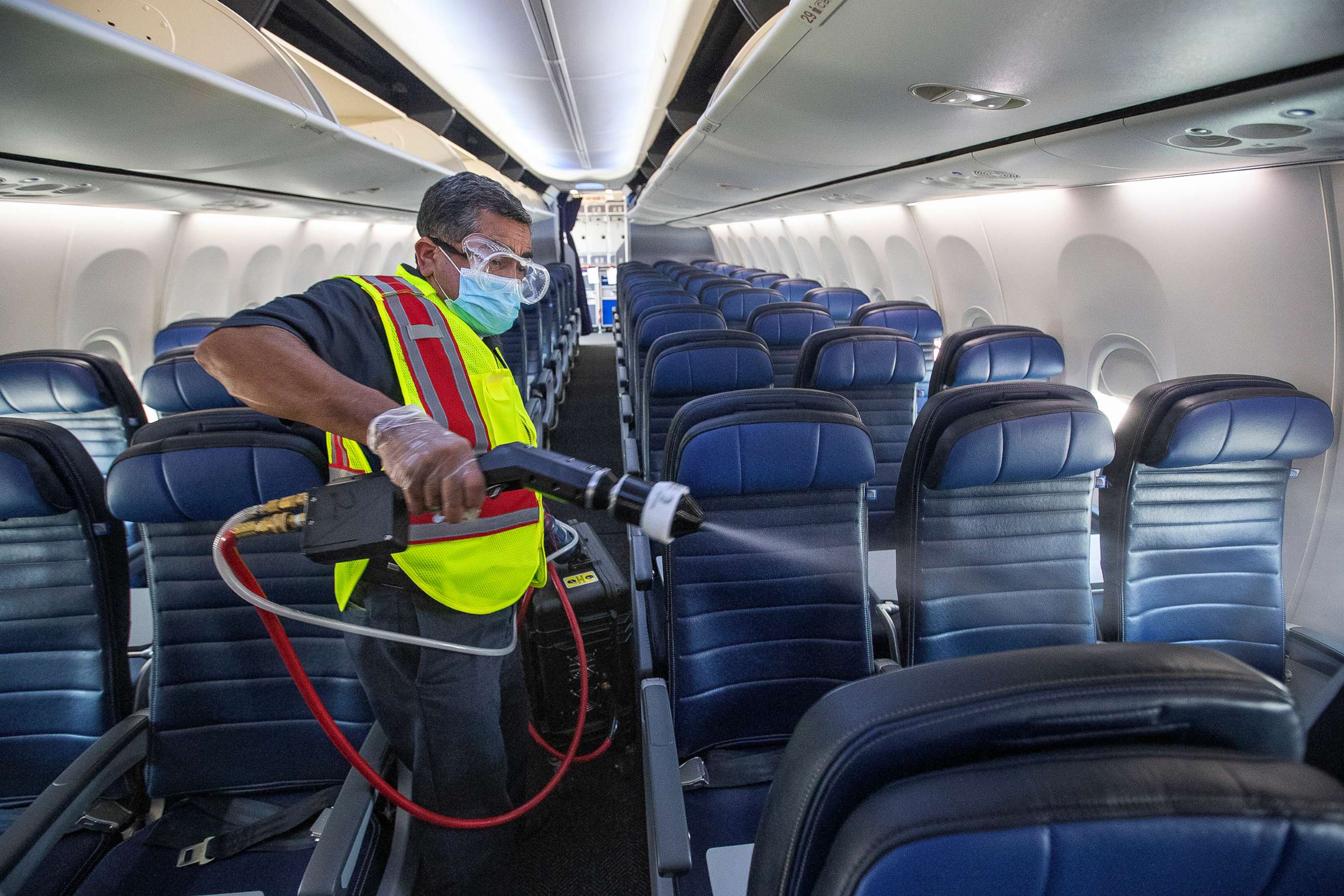 PHOTO: In this July 9, 2020, file photo, cleaning supervisor Jose Mendoza uses an electrostatic sprayer to disinfect the cabin area of a United Airlines 737 jet before passengers are allowed to board at LAX in Los Angeles.