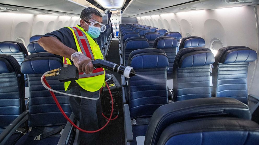 PHOTO: In this July 9, 2020, file photo, cleaning supervisor Jose Mendoza uses an electrostatic sprayer to disinfect the cabin area of a United Airlines 737 jet before passengers are allowed to board at LAX in Los Angeles.