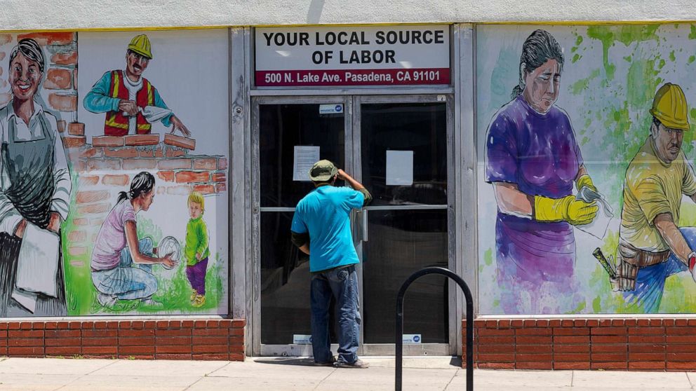 PHOTO: A person looks inside the closed doors of the Pasadena Community Job Center in Pasadena, Calif., May 7,2020.
