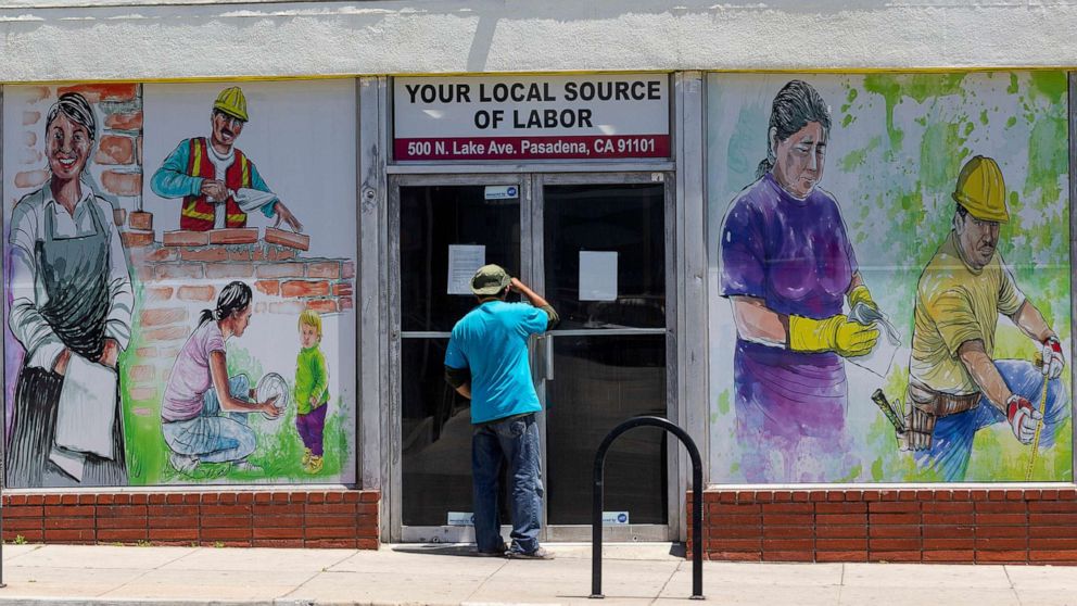 PHOTO: A person looks inside the closed doors of the Pasadena Community Job Center in Pasadena, Calif., May 7,2020.