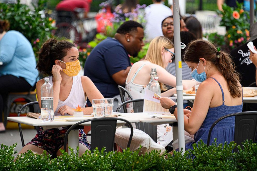 PHOTO: People wear protective face masks at an outdoor restaurant in the Flatiron District as the city continues Phase 4 of re-opening following restrictions imposed to slow the spread of coronavirus on July 26, 2020 in New York City.