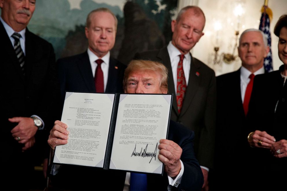 PHOTO: President Donald Trump displays signs a presidential memorandum imposing tariffs and investment restrictions on China in the Diplomatic Reception Room of the White House, March 22, 2018.
