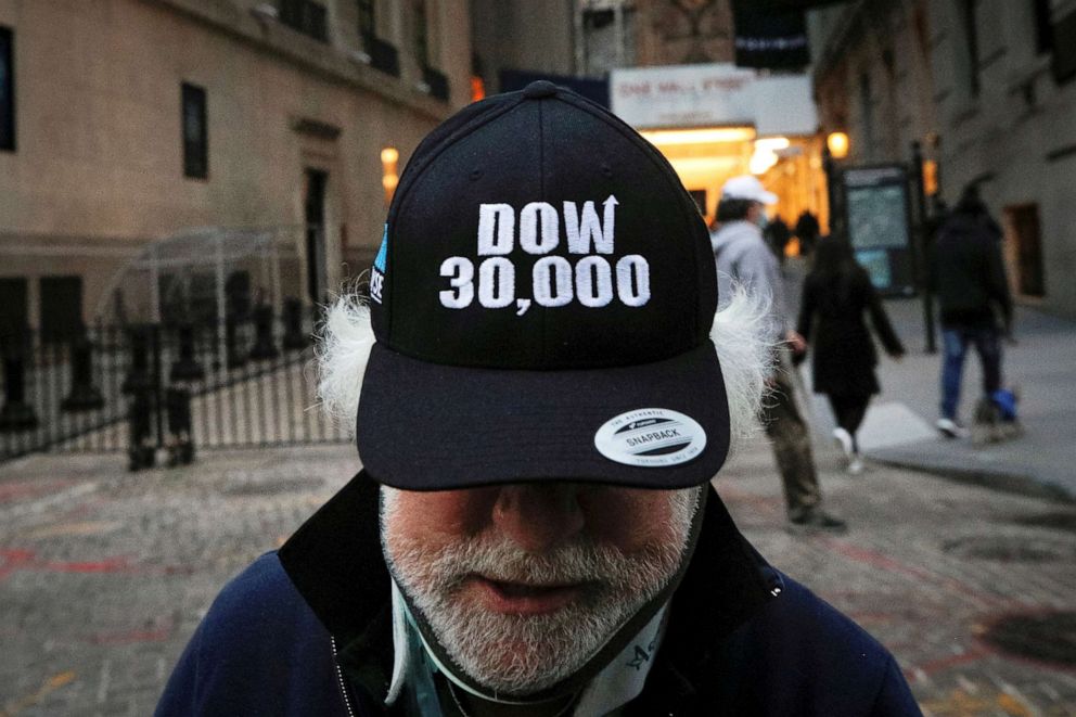 PHOTO: Trader Peter Tuchman wears a DOW 30,000 hat as he greets friends outside the New York Stock Exchange (NYSE) in New York, N.Y., Nov. 24, 2020.