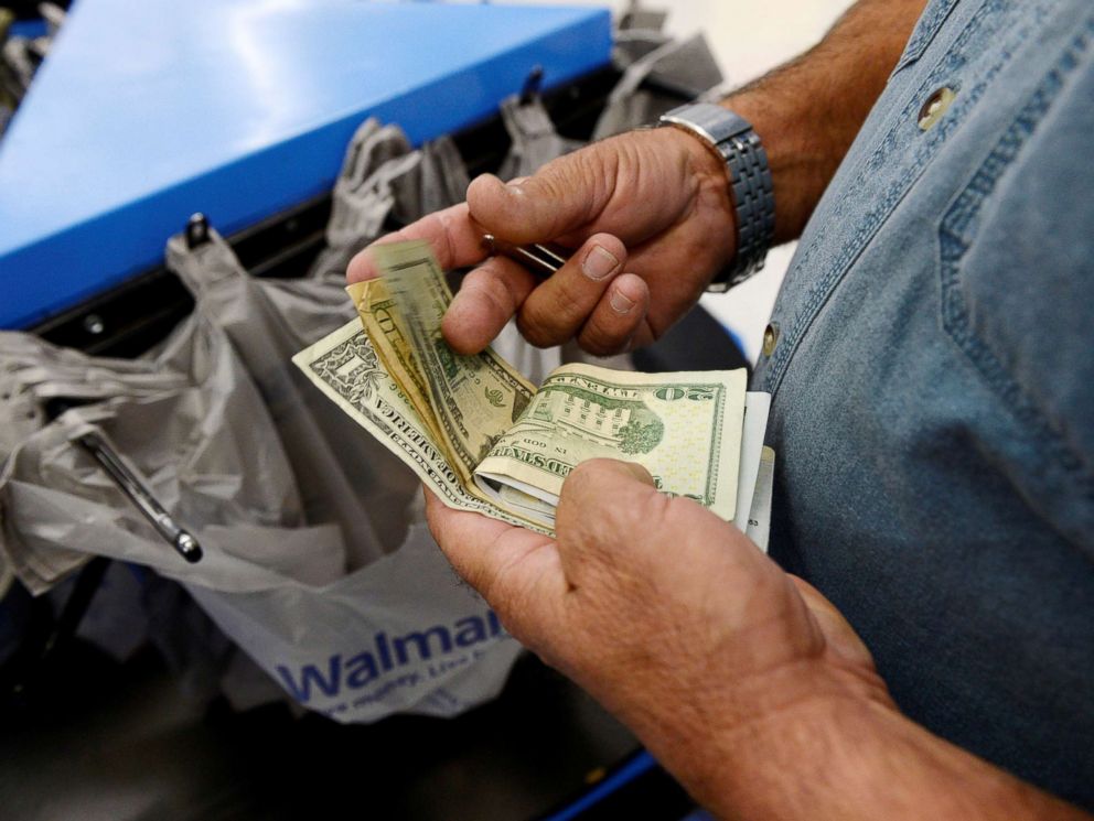 PHOTO: A customer counts his cash at the checkout lane of a Walmart store in the Porter Ranch section of Los Angeles, Nov. 26, 2013.