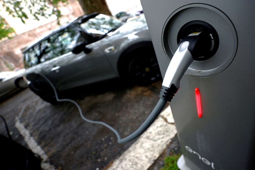 PHOTO: An electric car is seen plugged in at a charging point for electric vehicles in Rome, April 28, 2021.