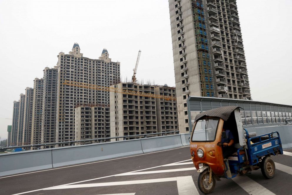 PHOTO: A vehicle drives past unfinished residential buildings at Evergrande Oasis, a housing complex developed by Evergrande Group, in Luoyang, China Sept. 16, 2021.