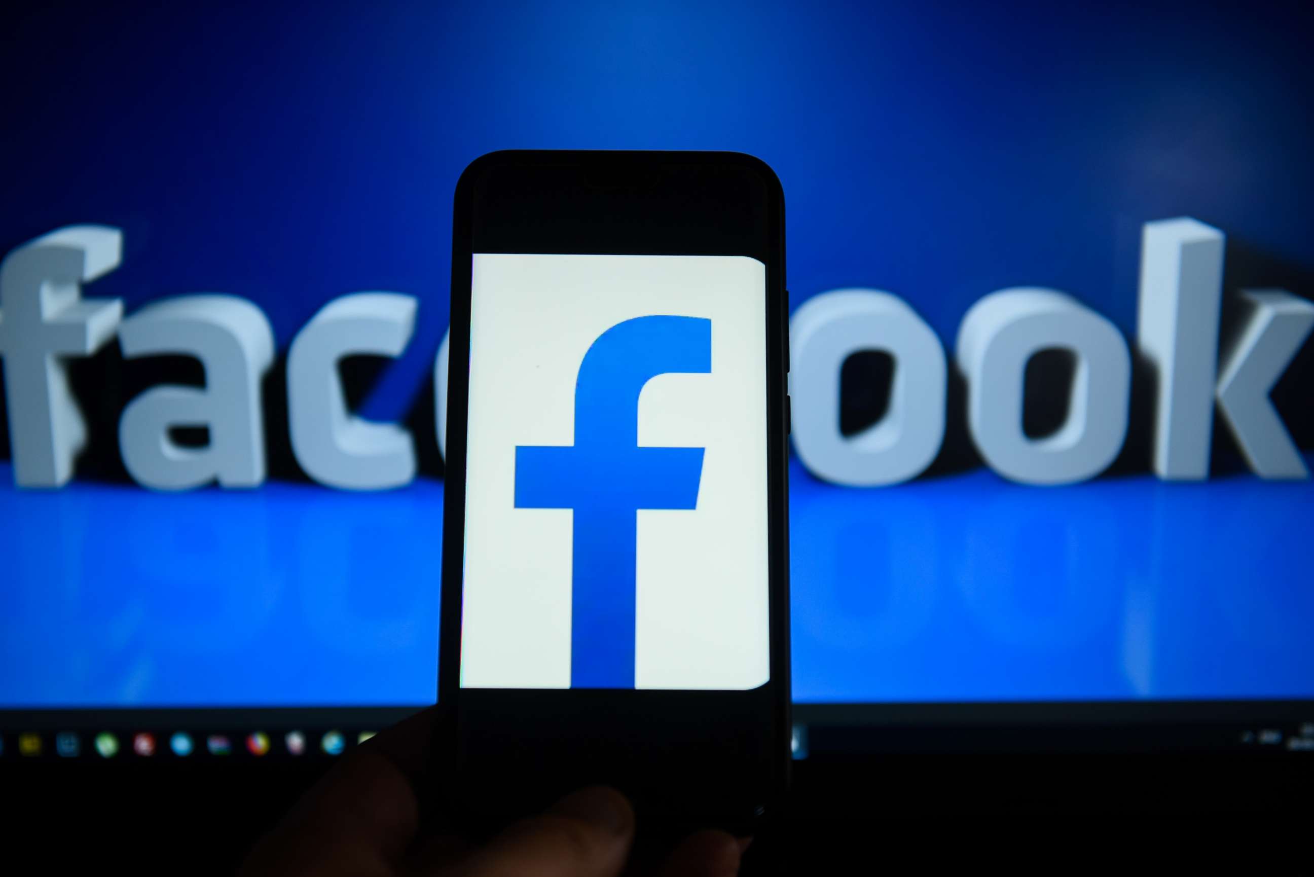 PHOTO: Facebook logo is seen on an android mobile phone in front of a computer screen. 