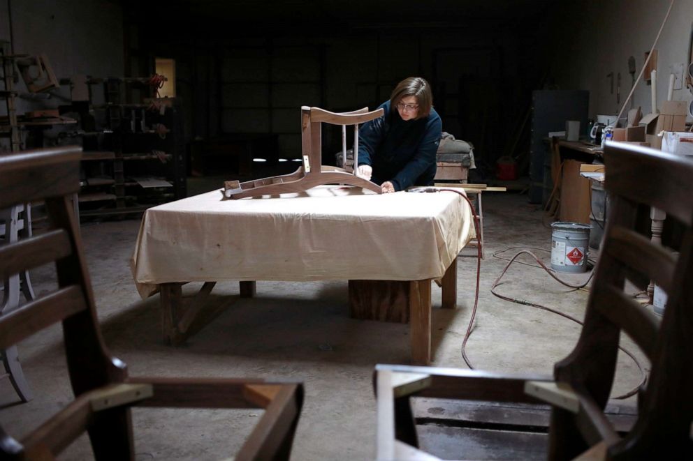PHOTO: A factory worker uses sandpaper on a handmade wooden chair at the Colonial House Furniture Inc. wood shop in Auburn, Kentucky, Dec. 1, 2021.