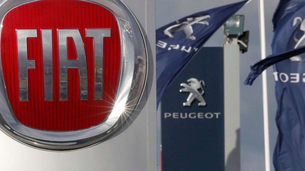PHOTO: The logos of car manufacturers Fiat and Peugeot are seen in front of dealerships of the companies in Saint-Nazaire, France, Nov. 8, 2019.