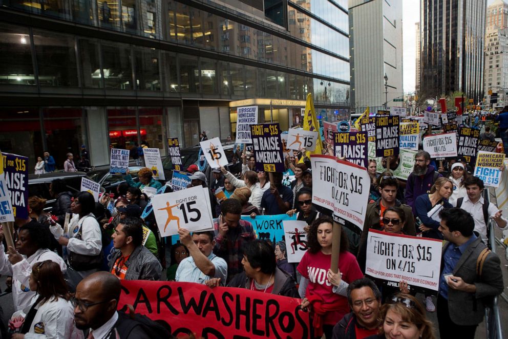 PHOTO: Protesters hold signs at a rally in support of minimum wage increase in New York, April 15, 2015.