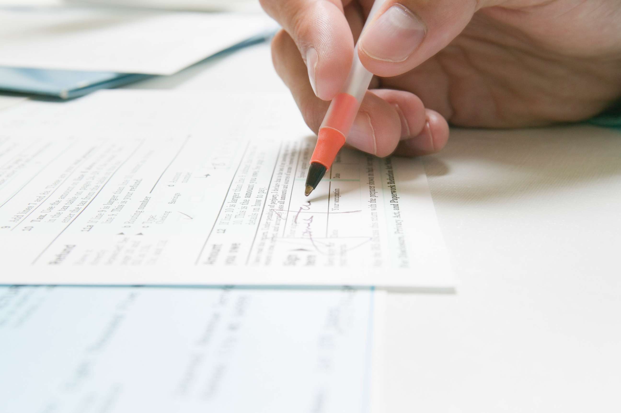 PHOTO: In this undated stock photo, a man signs an IRS tax form.