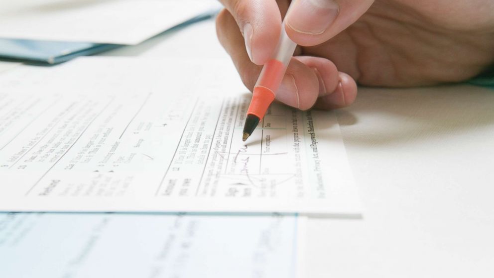 PHOTO: In this undated stock photo, a man signs an IRS tax form.