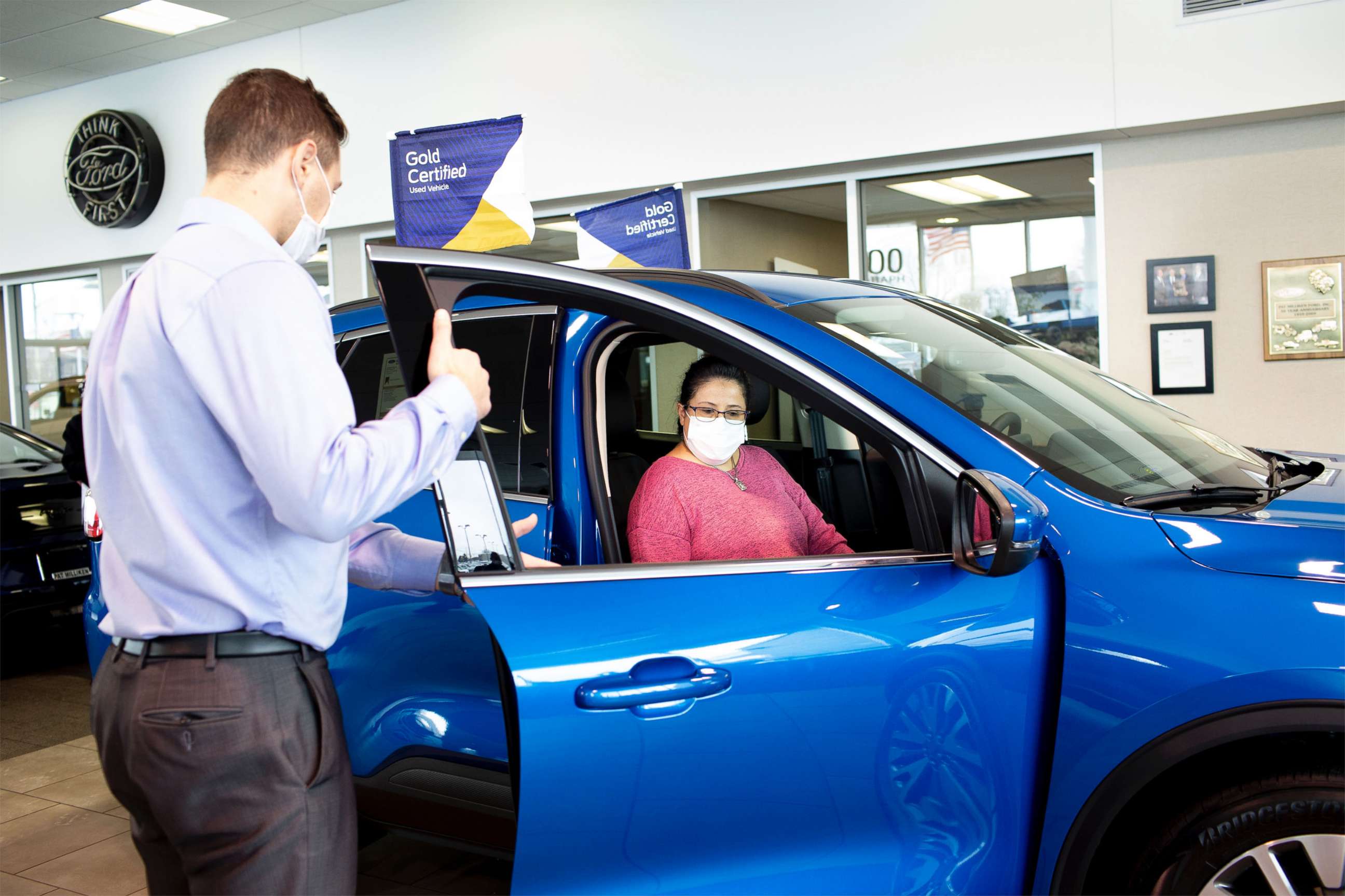 PHOTO: A potential Ford customer works with a sales associate at a local Ford dealership.