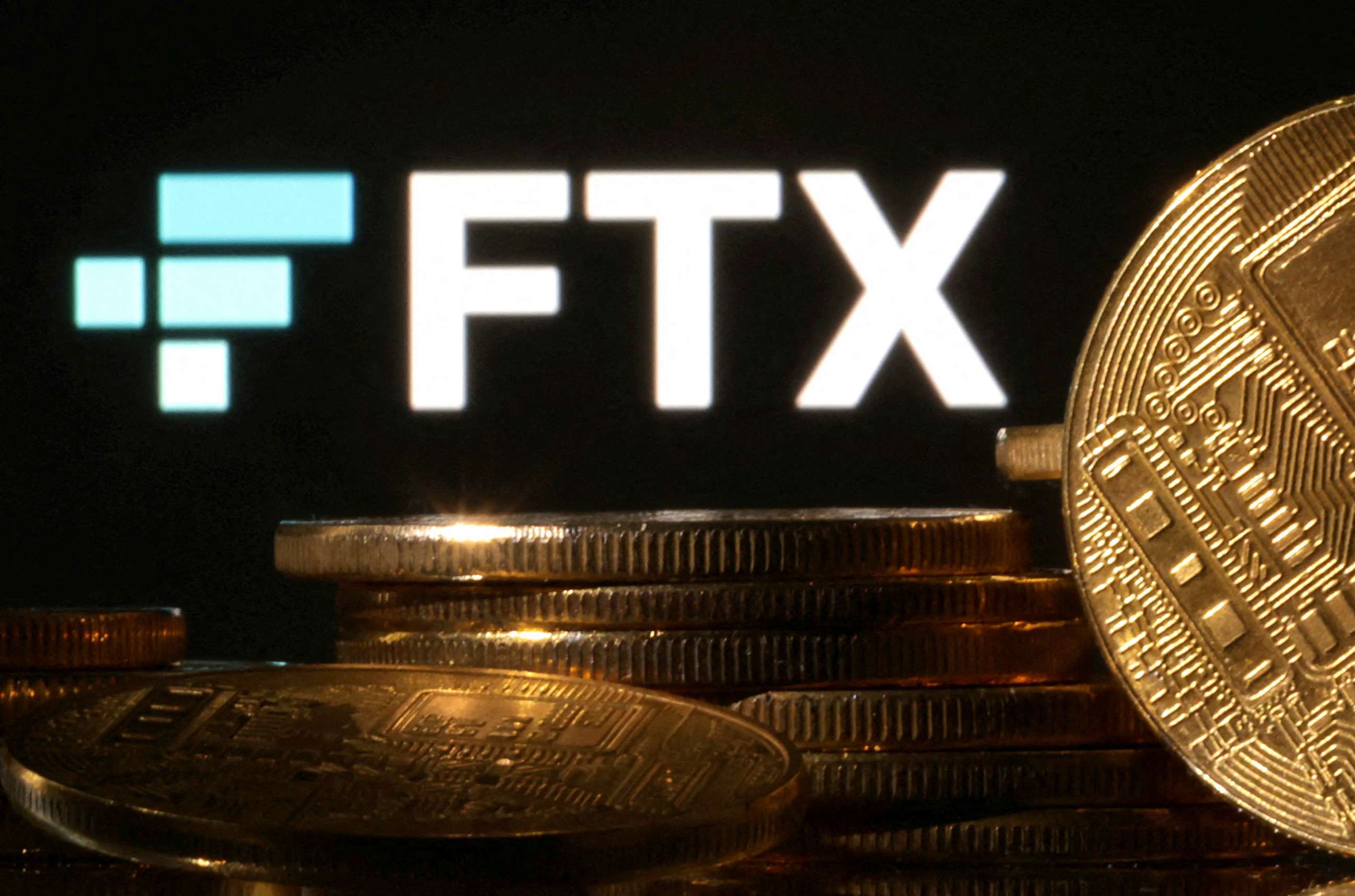 PHOTO: Representations of cryptocurrencies are seen in front of displayed FTX logo.