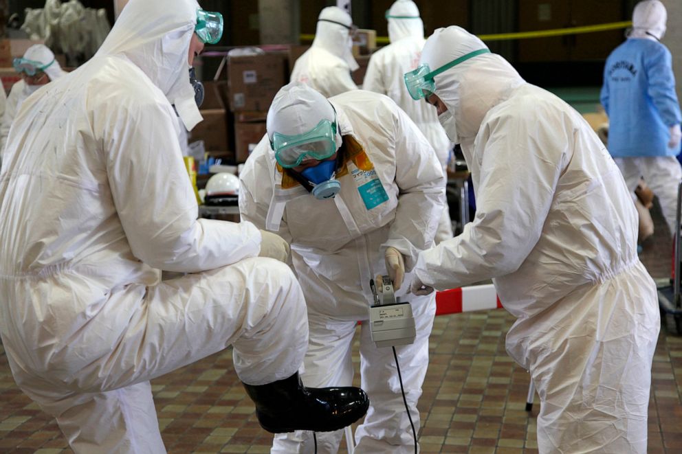PHOTO: Radiation scanning crews check eath other's levels as they change their working shift at a screening centre in Koriyama in Fukushima prefecture, west of TEPCO's striken Fukushima No.1 nuclear power plant, March 18, 2011.