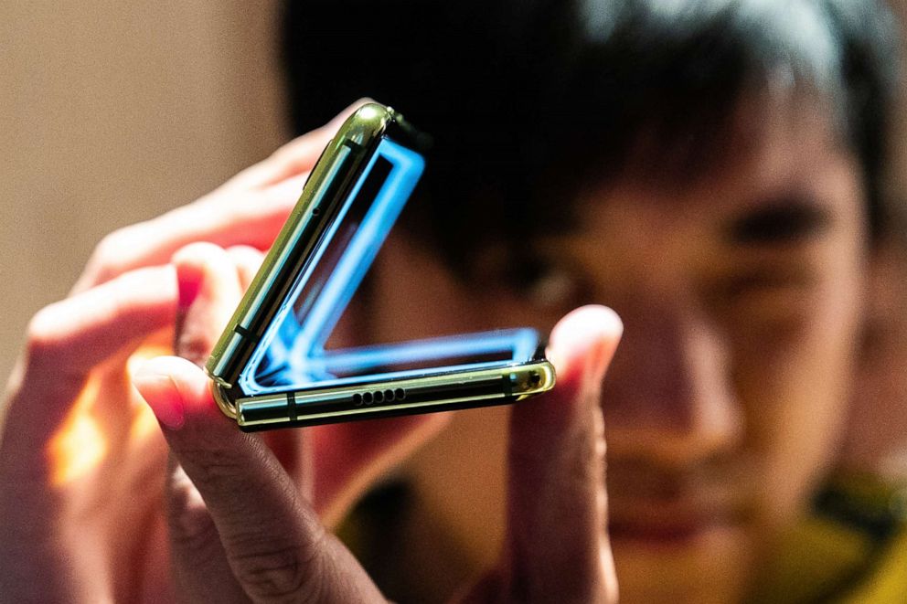 PHOTO: An attendee holds a Samsung Galaxy Fold mobile device during an unveiling event in New York, on Monday, April 15, 2019.