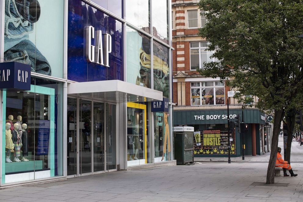 PHOTO: A man sits outside a closed Gap store on Oxford Street as shops and businesses remain closed on May 1, 2020 in London.