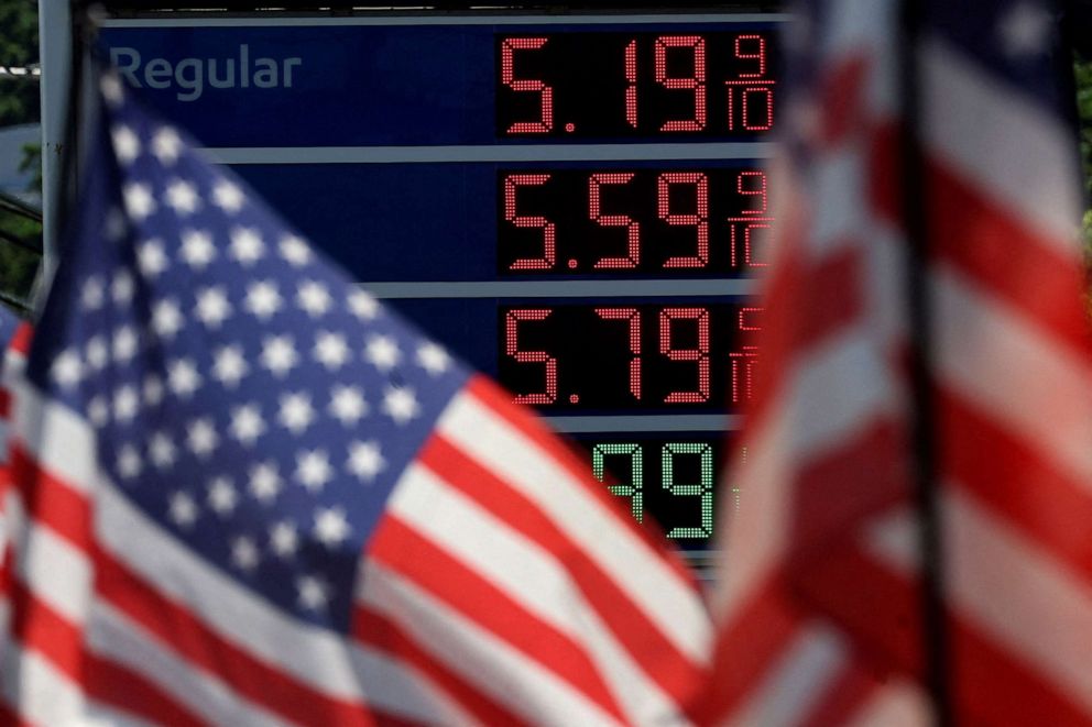 PHOTO: Gas prices are displayed at an Exxon gas station behind American flag in Edgewater, N.J., June 14, 2022.
