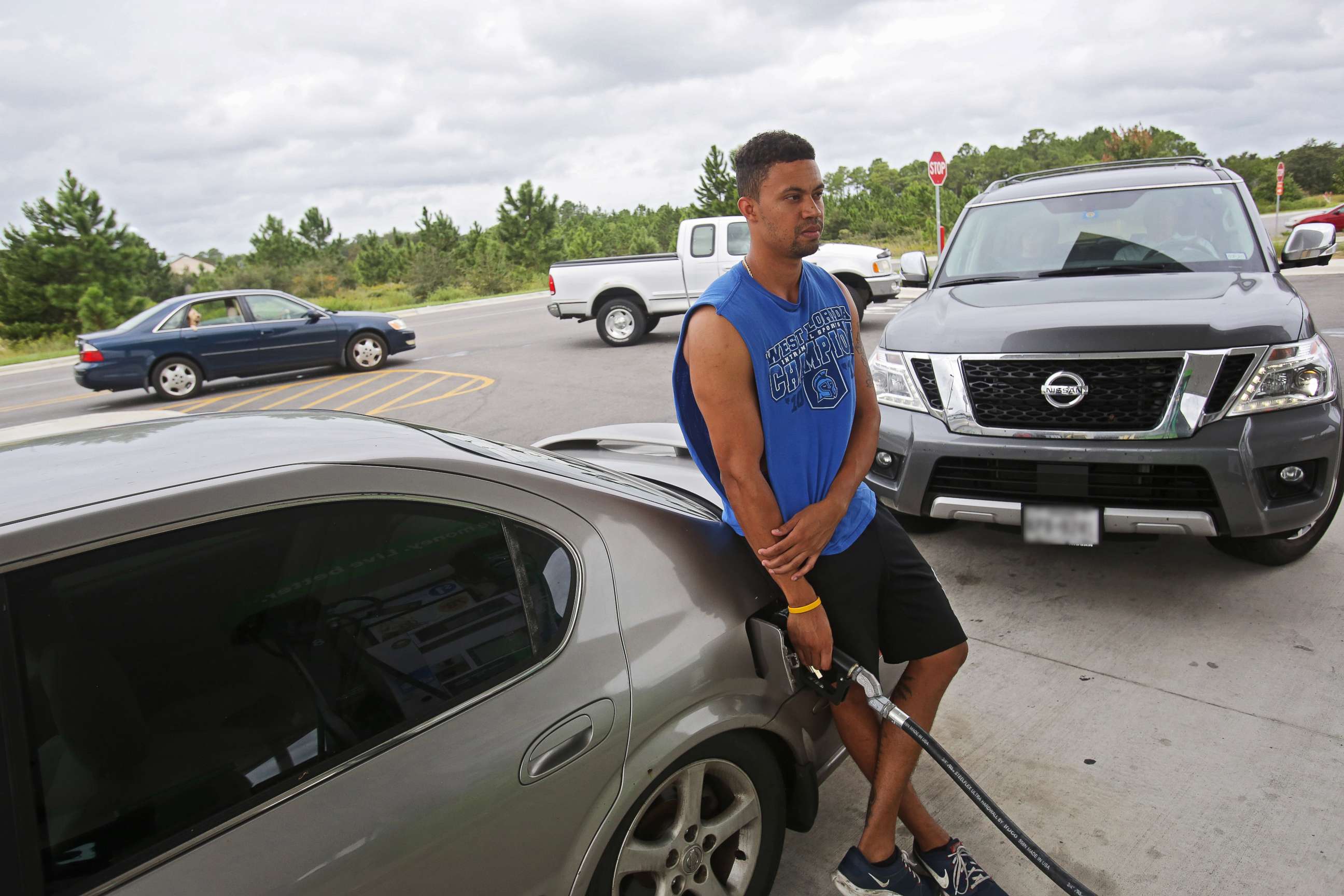 PHOTO: Andre Selby fills up his car while vehicles behind him line up for gasoline as people prepare for Hurricane Michael in Navarre, Fla., Oct. 9, 2018. 