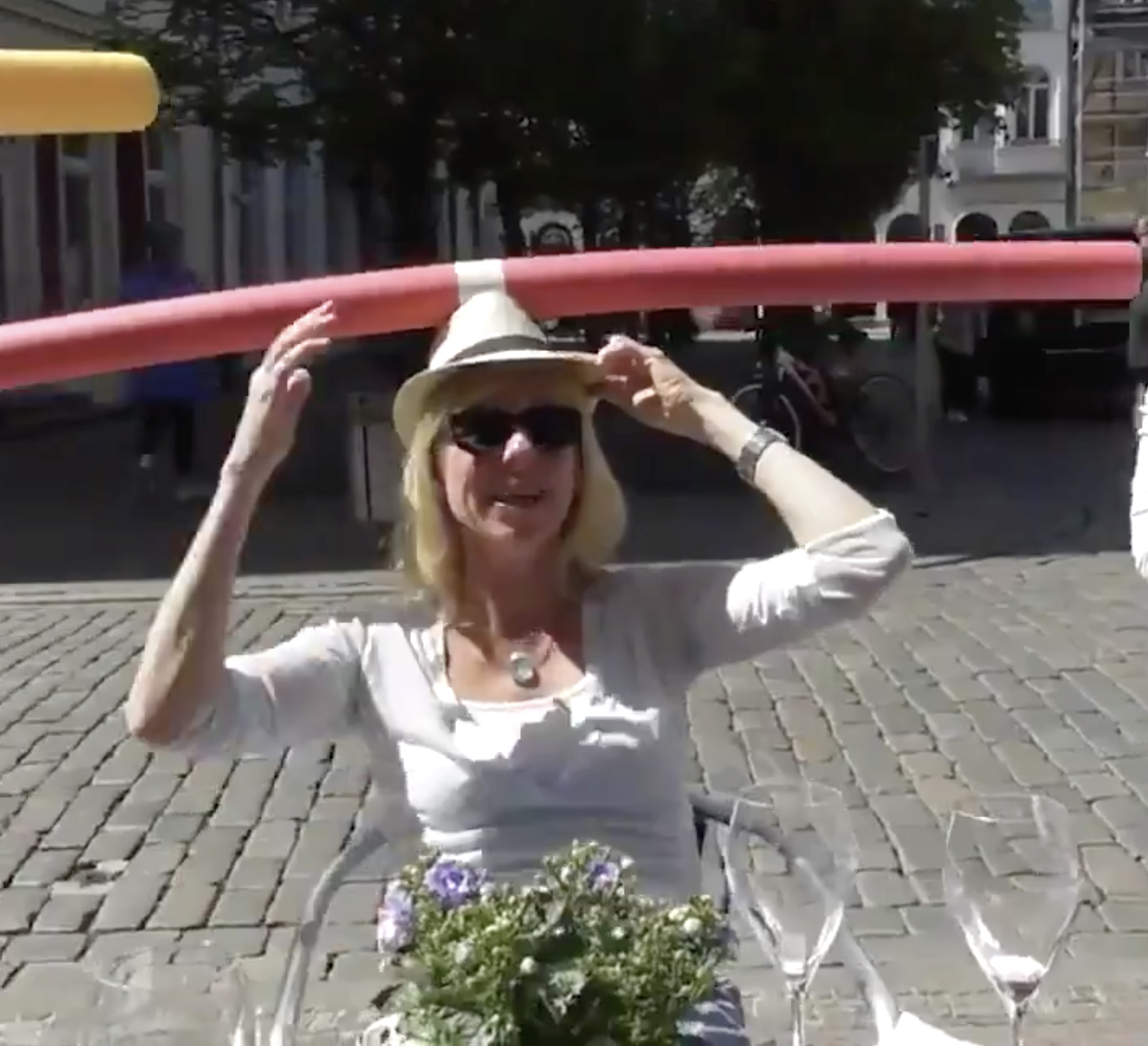 PHOTO: In this screen grab taken from a video posted to social media, a woman at a cafe in Germany wears a pool noodle to encourage social distancing.