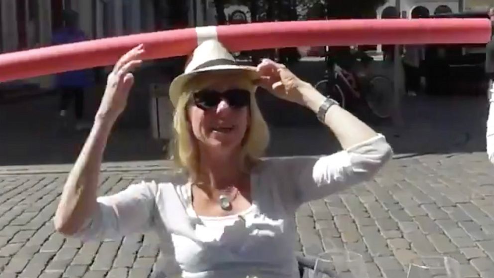 PHOTO: In this screen grab taken from a video posted to social media, a woman at a cafe in Germany wears a pool noodle to encourage social distancing.
