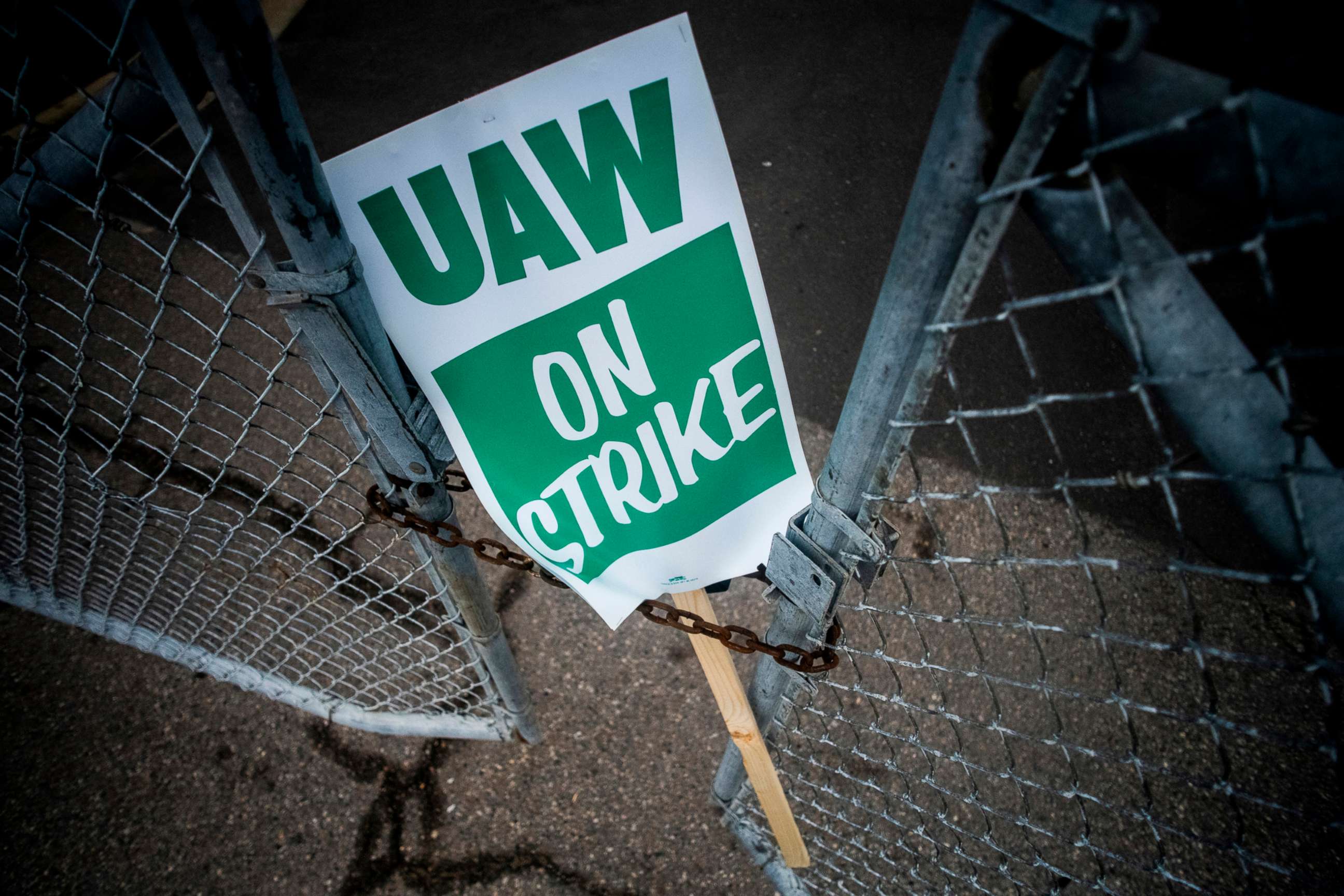 PHOTO: A United Auto Workers strike sign rests between the chains of a locked gate entrance outside of Flint Engine Operations in Flint, Mich., Sept. 16, 2019.