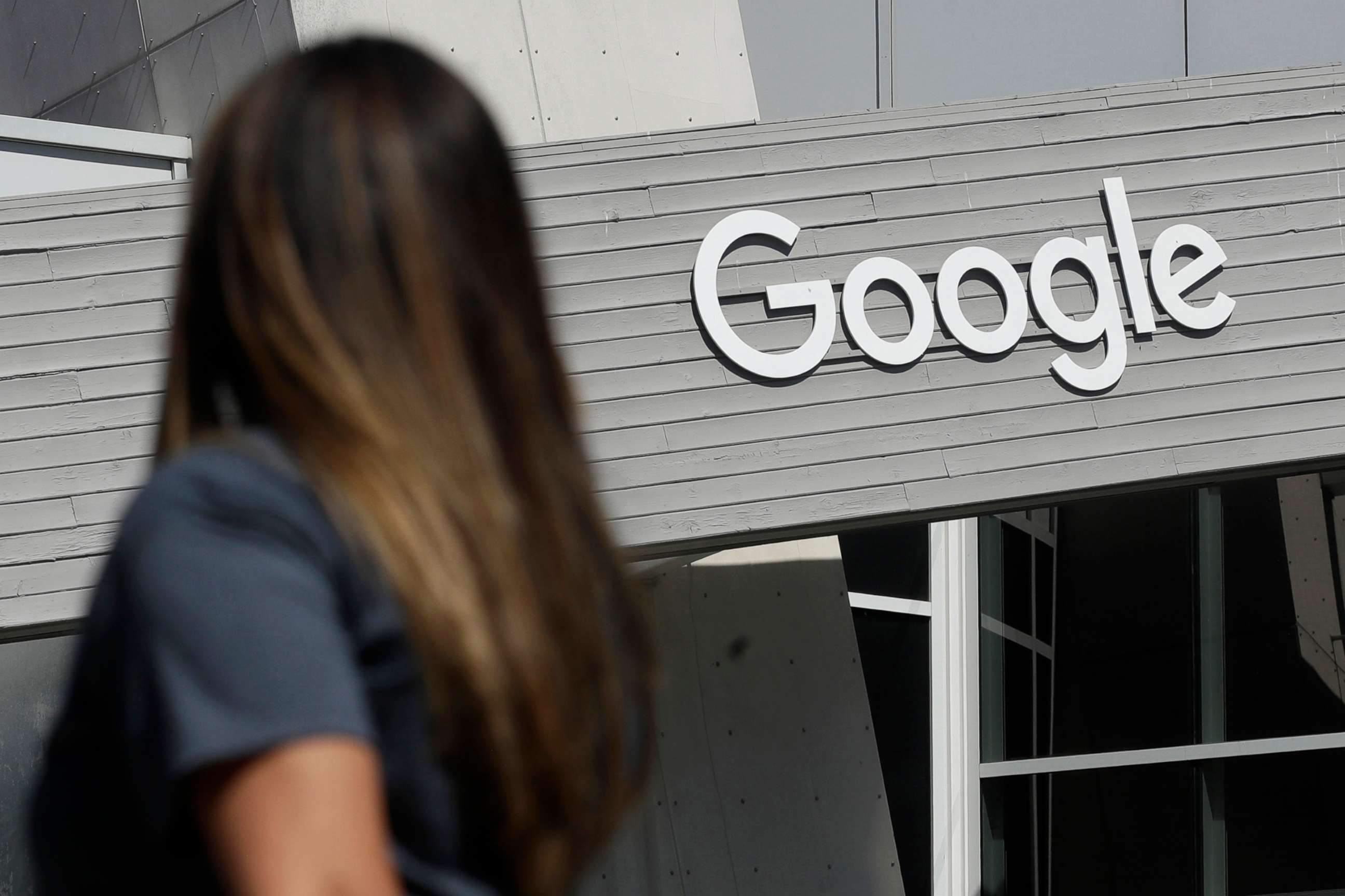 PHOTO: A woman walks past a sign on the Google campus in Mountain View, Calif., Sept. 24, 2019.