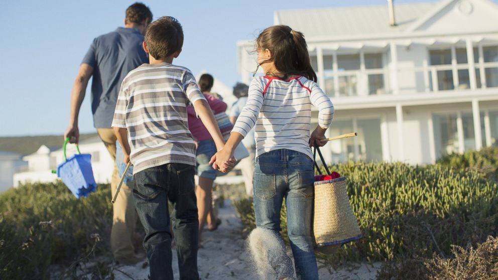 A family walks towards their beach rental in an undated stock photo. 
