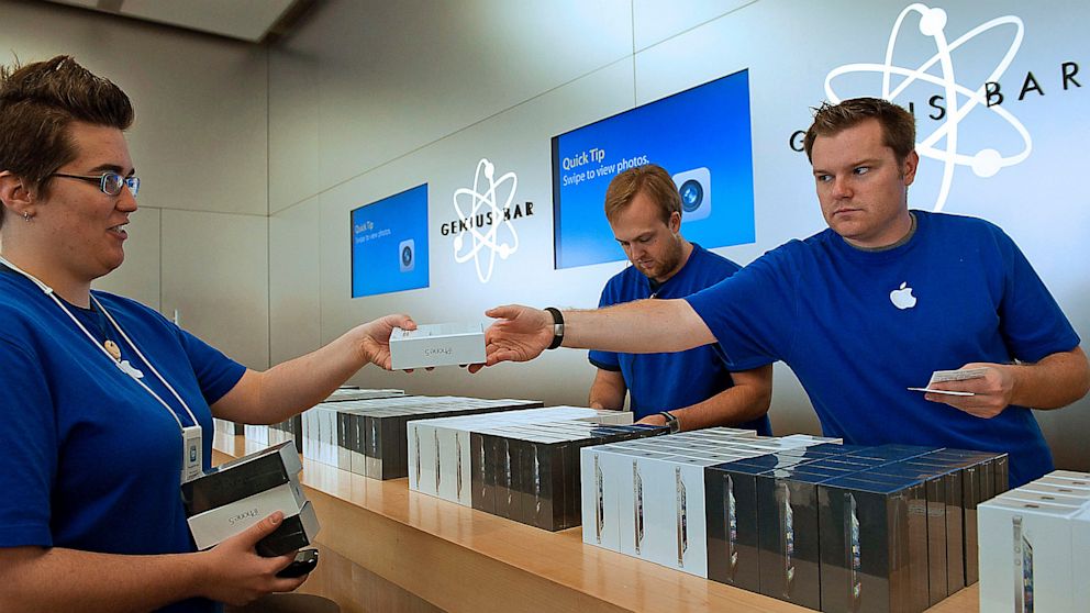 Employees hand off new iPhone 5 smartphones at an Apple Store in San Francisco, in this Sept. 21, 2012 photo.
